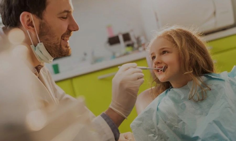 Young child smiles to the dentist while getting teeth checked