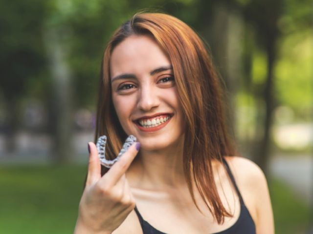 Beautiful,Smiling,Turkish,Woman,Is,Holding,An,Invisalign,Bracer,With
