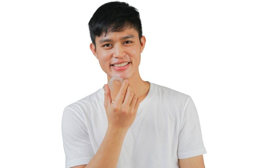 Close,Up,Young,Asian,Man,Smiling,With,Hand,Holding,Dental