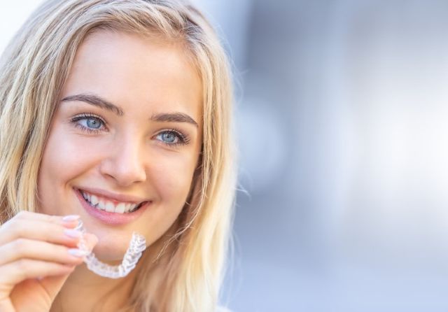 Invisalign,Orthodontics,Concept,-,Young,Attractive,Woman,Holding,-,Using