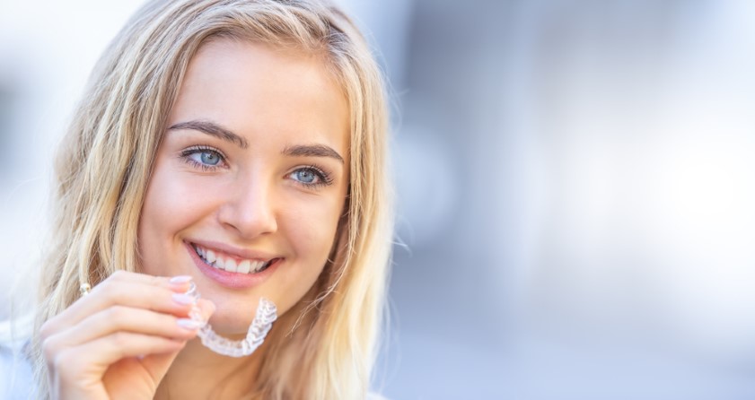 Invisalign,Orthodontics,Concept,-,Young,Attractive,Woman,Holding,-,Using